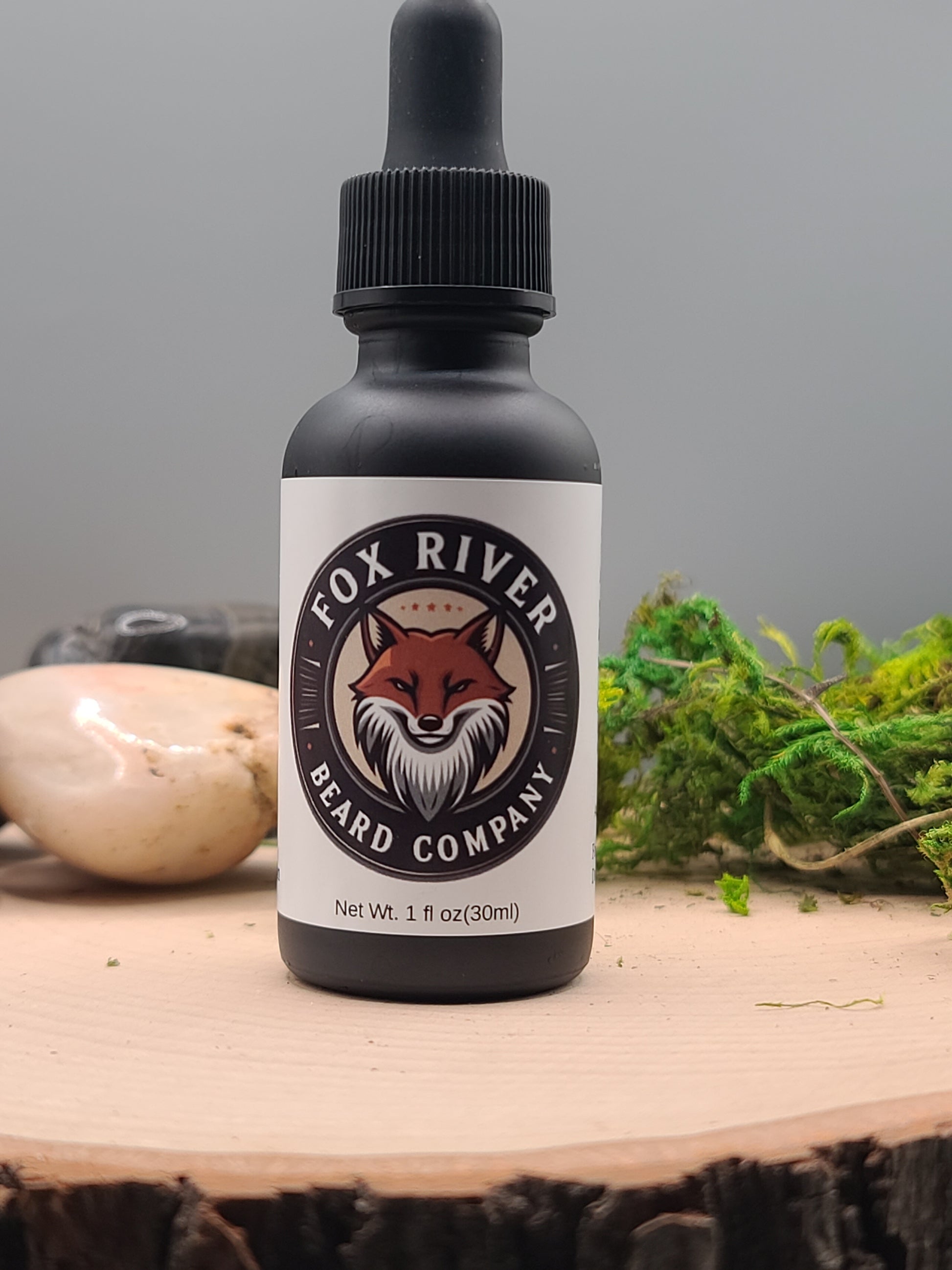Bottle of River Fox Beard Company beard oil on a wooden surface with a natural background