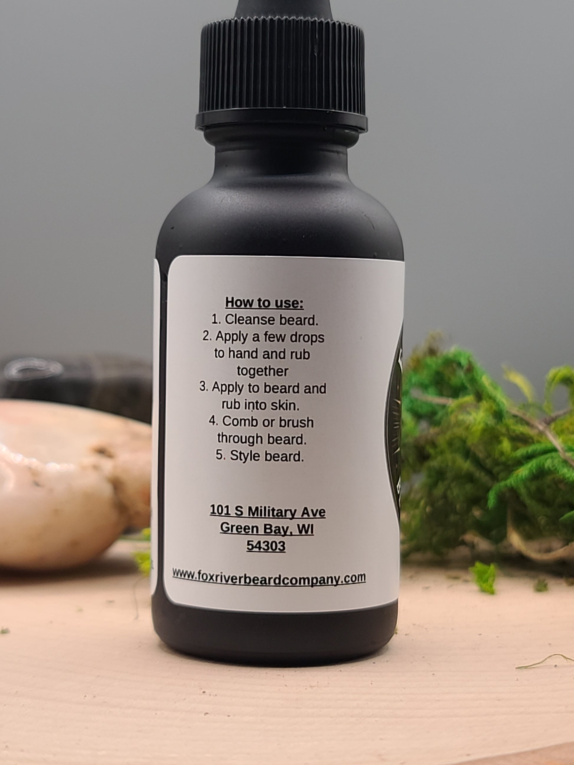 Bottle of beard oil with label on a wooden surface